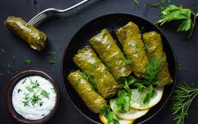 Аппетитная долма с кусочками лимона на столе 