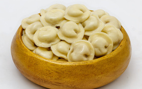 Appetizing dumplings in a wooden bowl on a gray background