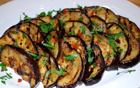 Аппетитные жареные баклажаны на тарелке с зеленью