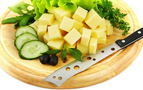 Сыр нарезанный кубиками на разделочной доске