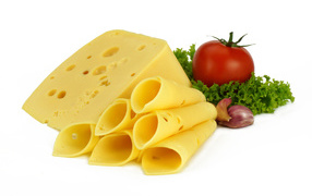 Сырная нарезка с помидором, листьями салата и чесноком на белом фоне