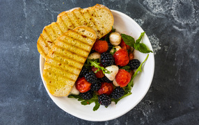 Croissants with berry salad on a white plate