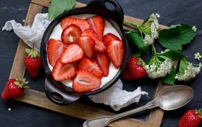 Свежая клубника с йогуртом на завтрак на столе с белым цветком