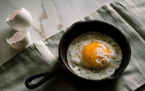Fried eggs on a table in a small frying pan
