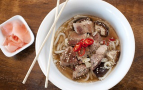 Хайнаньский суп с бараниной, лапшой и кунжутом в белой миске