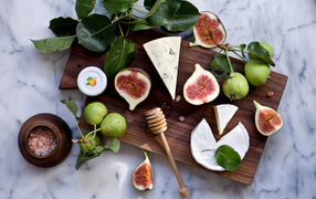 Pears with figs and cheese on a cutting board