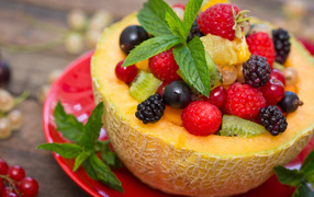 Аппетитные свежие ягоды с листьями мяты в половине дыни