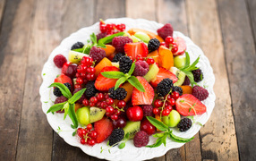 Аппетитные свежие фрукты на белой тарелке 