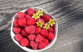 Аппетитная сочная свежая малина в белой тарелке 