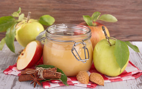 Банка яблочного джема с пряностями на столе