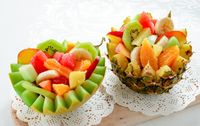 Delicious fruit salad in melon and pineapple bowls