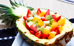 Fruit salad of citrus fruits in a plate of fresh pineapple