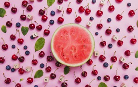 Половина арбуза с ягодами вишни и черники на столе