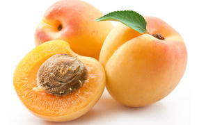 Three ripe large apricots on a white background