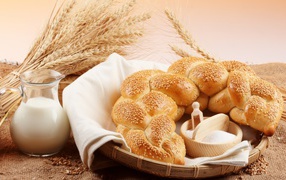 Хлебобулочное изделие и кувшин молока на столе