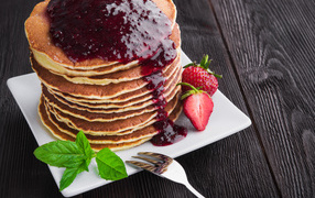 Appetizing pancakes with jam and strawberries