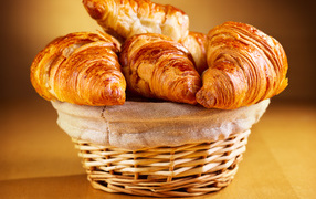 Basket with fresh croissants on the table