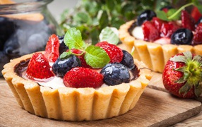 Пирожное с кремом и свежими ягодами черники и клубники