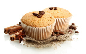 Muffins with grains of coffee and cinnamon on a white background