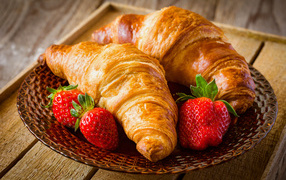 Two fresh croissants with fresh strawberries