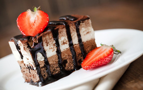 Кусок шоколадного пирожного со свежей клубникой