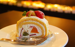 Кусок сладкого бисквитного рулета с клубникой 