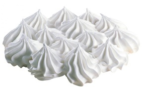 Воздушные взбитые сливки на белом фоне