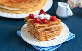 Appetizing delicate pancakes with raspberry and syrup