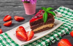 Аппетитный кусок торта на тарелке с ягодами клубники