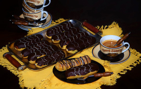 Аппетитные сладкие эклеры с шоколадом и чашками кофе на столе