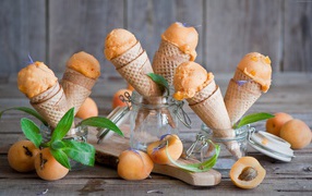 Абрикосовое мороженое в вафельных рожках со свежими фруктами на столе