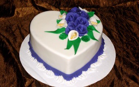 Beautiful cake in the shape of a heart decorated with flowers