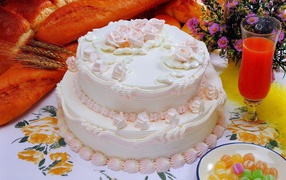 Красивый праздничный торт с кремом на столе с соком и хлебом