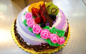 Красивый торт с фруктами украшен розовыми розами из крема