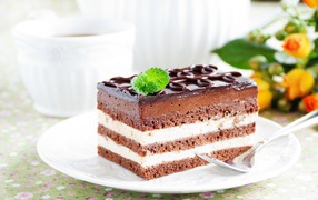 Пирожное с шоколадным и сливочным кремом на белой тарелке