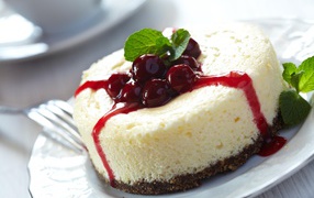 Cheesecake with cherry jam and mint leaves
