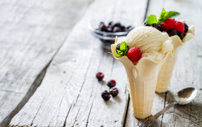 Сливочное мороженое в вафельном стаканчике с ягодами
