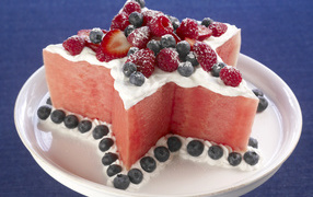 Dessert of watermelon with cream and raspberries, strawberries and blueberries