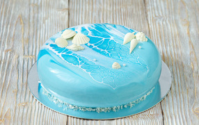 Глянцевый торт голубого цвета украшен сахарными ракушками