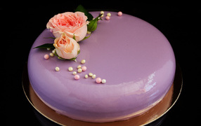 Глянцевый круглый фиолетовый торт с цветами розы на черном фоне