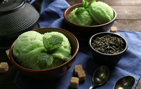 Зеленое мятное мороженое и кусочки сахара на столе 