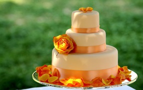 Large multi-tiered orange wedding cake with flowers