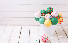 Multicolored lollipops in a white bucket