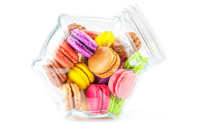 Multicolored macaroons in a glass jar on a white background