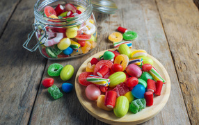Разноцветные мармеладные конфеты в стеклянной банке на столе