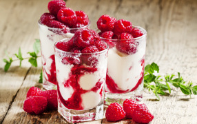 Сладкий десерт с йогуртом и малиной в стакане
