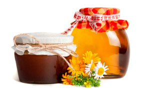 Две банки меда с цветами на белом фоне