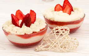 Two plates of sweet dessert with cream and strawberries