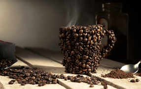 Чашка из кофейных зерен с горячим кофе 