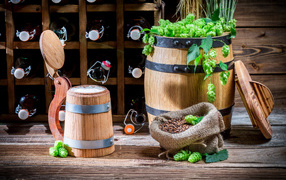 Бокал пива и деревянная бочка с хмелем на столе